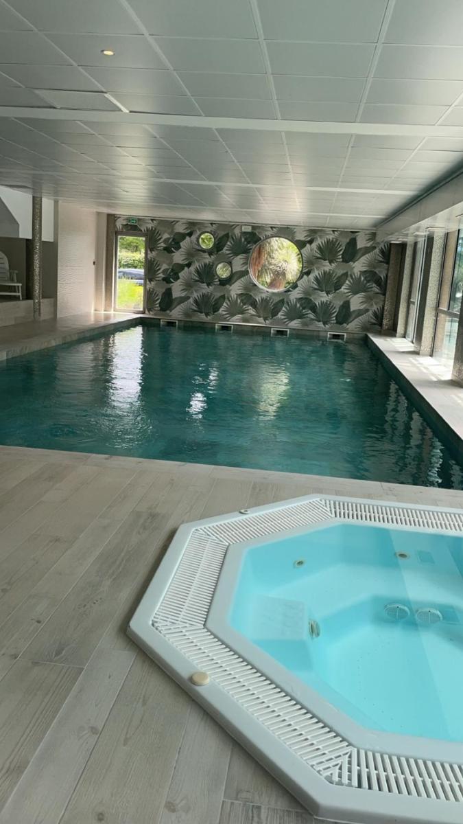 - une piscine avec un bain bleu dans un bâtiment dans l'établissement Best Western Aquakub, à Aix-les-Bains