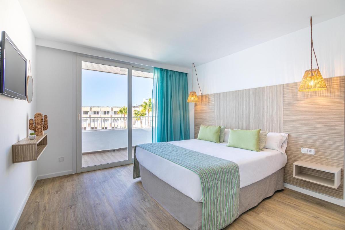 Una habitación de hotel con una cama y una ventana grande. en MarSenses Rosa del Mar Hotel & Spa, en Palmanova