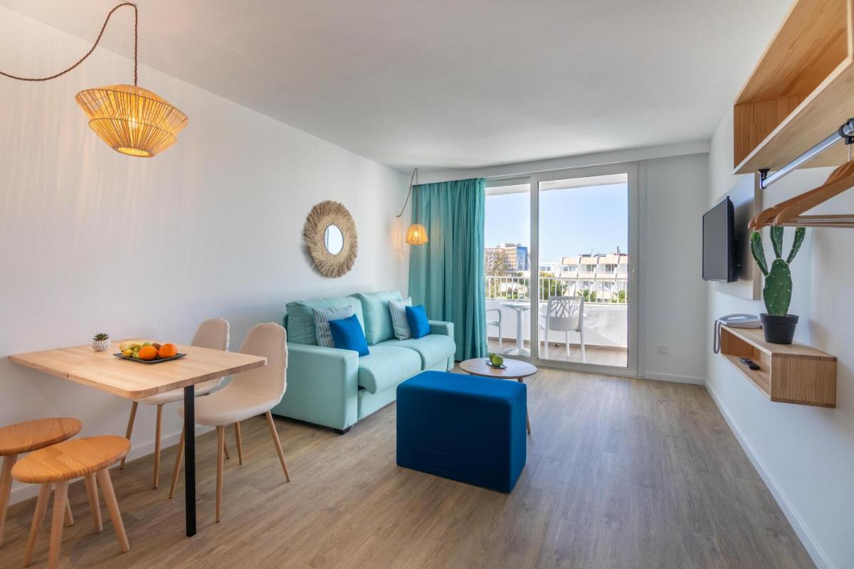 Una sala de estar con un sofá azul y una mesa. en MarSenses Rosa del Mar Hotel & Spa, en Palmanova