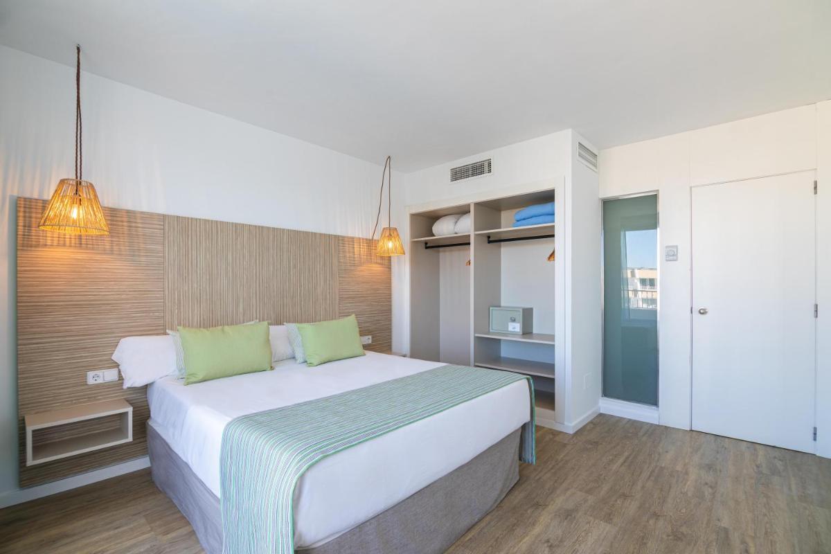 Un dormitorio con una gran cama blanca con almohadas verdes. en MarSenses Rosa del Mar Hotel & Spa, en Palmanova