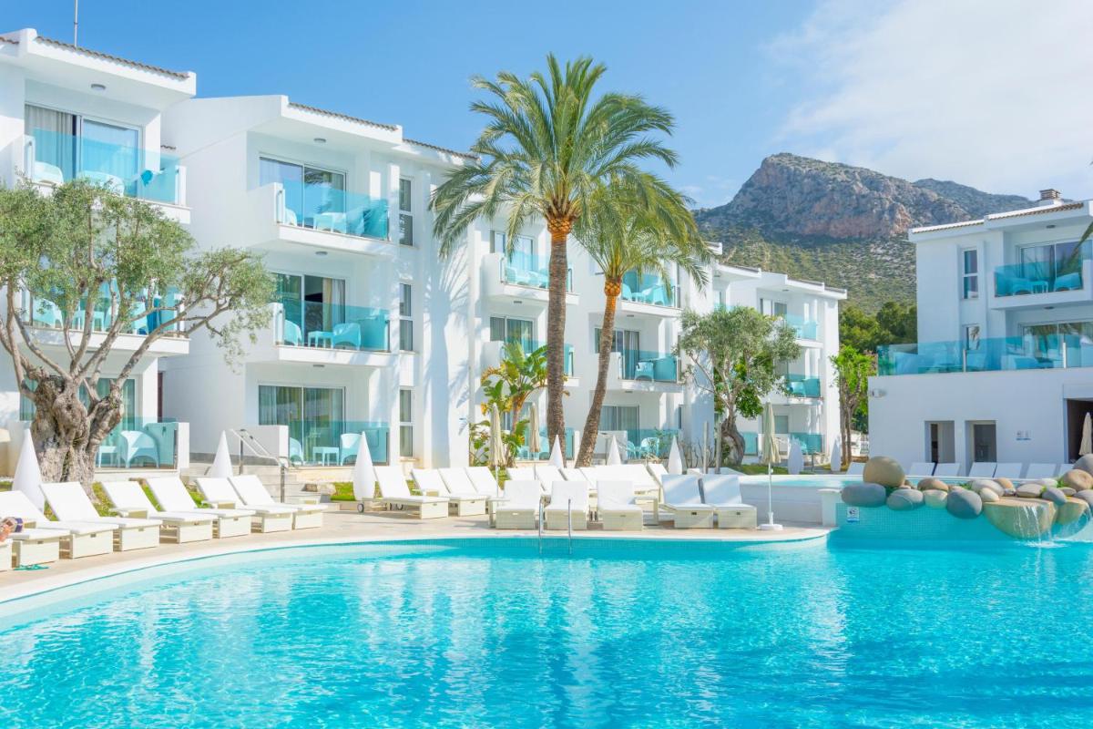 Una piscina frente a un hotel con edificios blancos. en MarSenses Puerto Pollensa Hotel & Spa Adults Only, en Puerto Pollensa