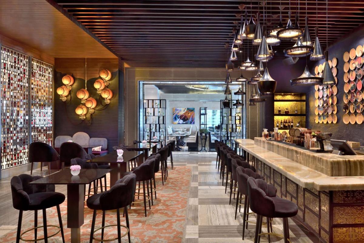 a restaurant with a bar with tables and chairs at The St. Regis Mumbai in Mumbai