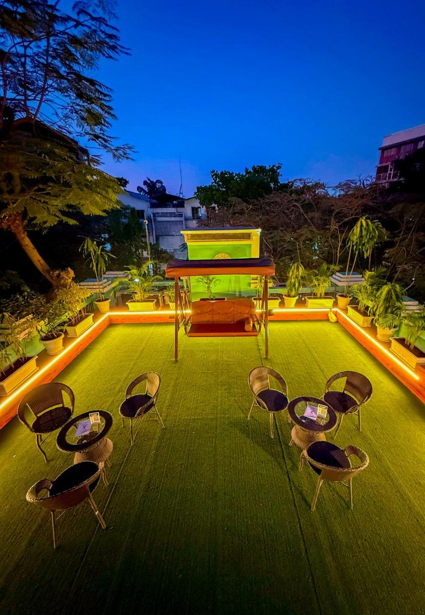a group of chairs and a table on a lawn at MyOtel - Santacruz in Mumbai