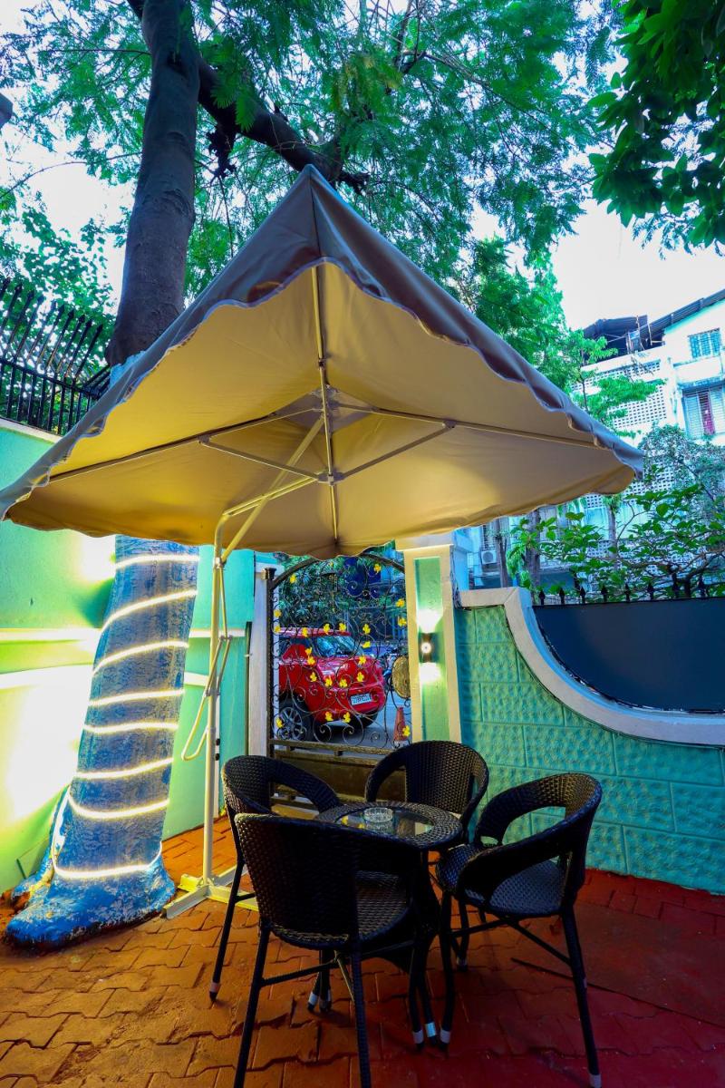 a table and chairs under an umbrella on a patio at MyOtel - Santacruz in Mumbai