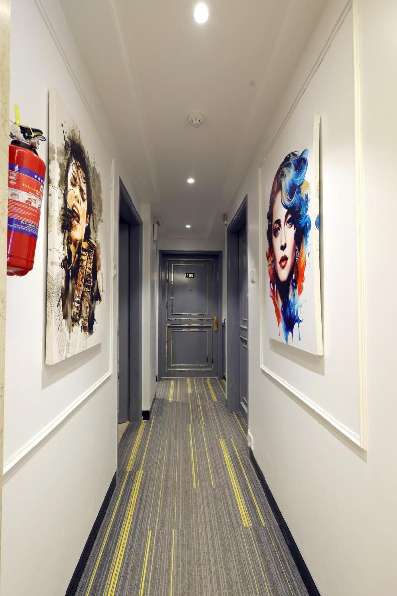 a hallway with paintings on the walls at MyOtel - Santacruz in Mumbai