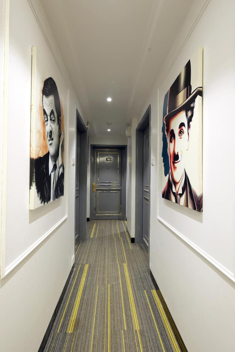 a hallway with paintings on the walls at MyOtel - Santacruz in Mumbai