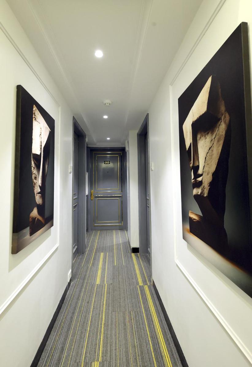 a hallway with paintings on the walls and a door at MyOtel - Santacruz in Mumbai