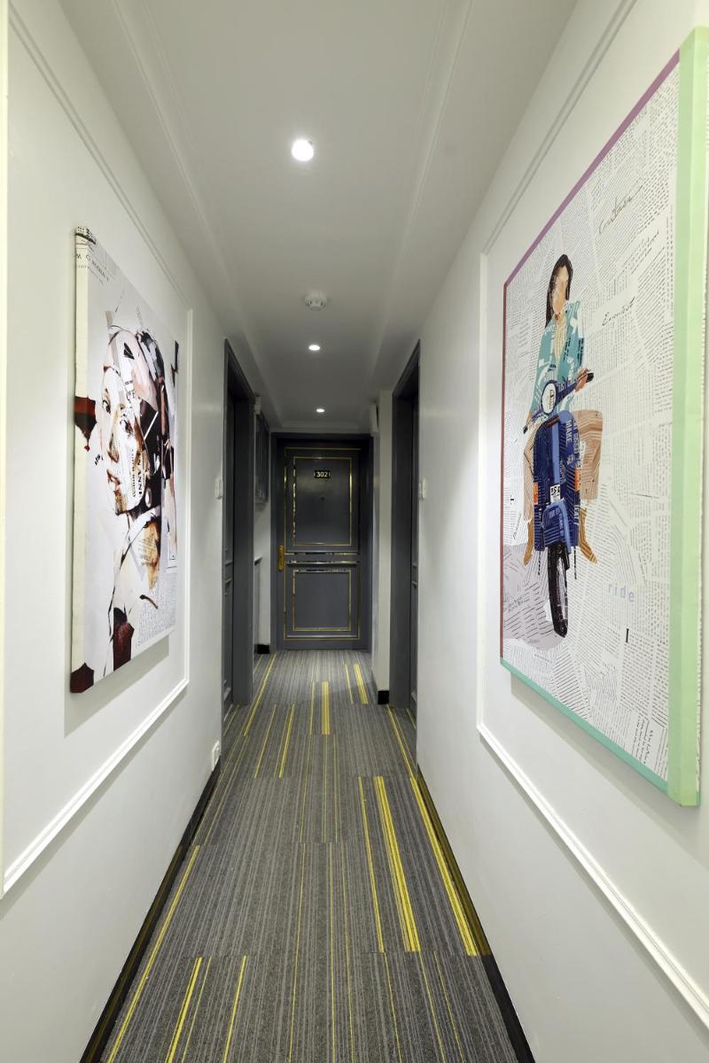 a hallway with paintings and a motorcycle on the wall at MyOtel - Santacruz in Mumbai