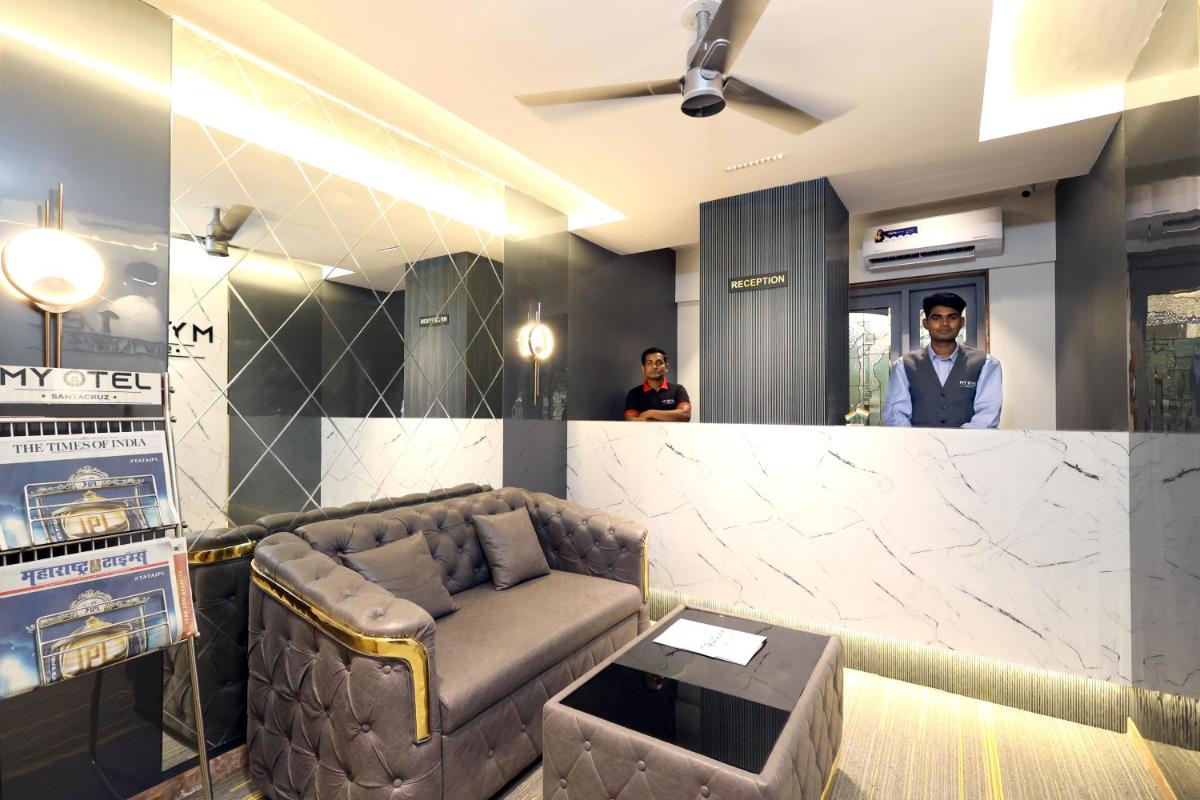 a waiting room with a couch and a bar at MyOtel - Santacruz in Mumbai