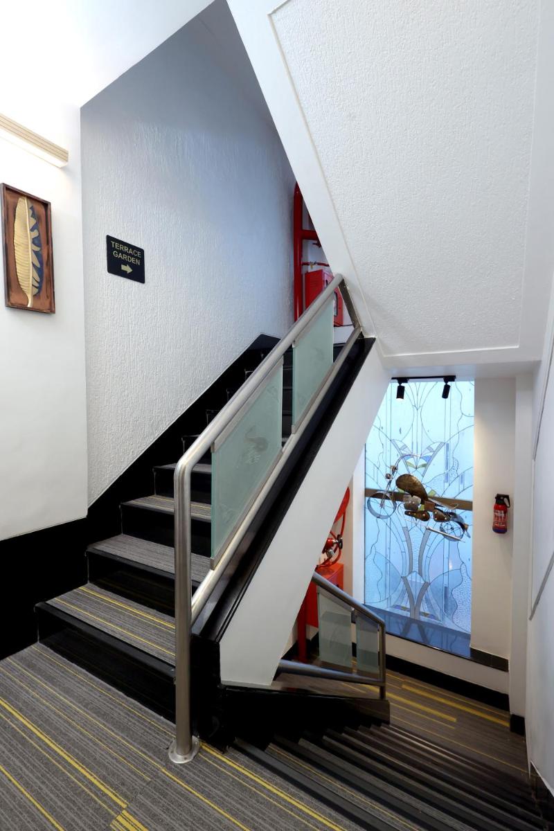 a staircase in a building with escalators and a window at MyOtel - Santacruz in Mumbai