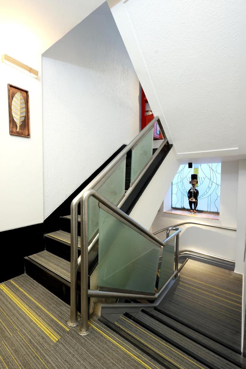 an escalator in a building with a person in a window at MyOtel - Santacruz in Mumbai