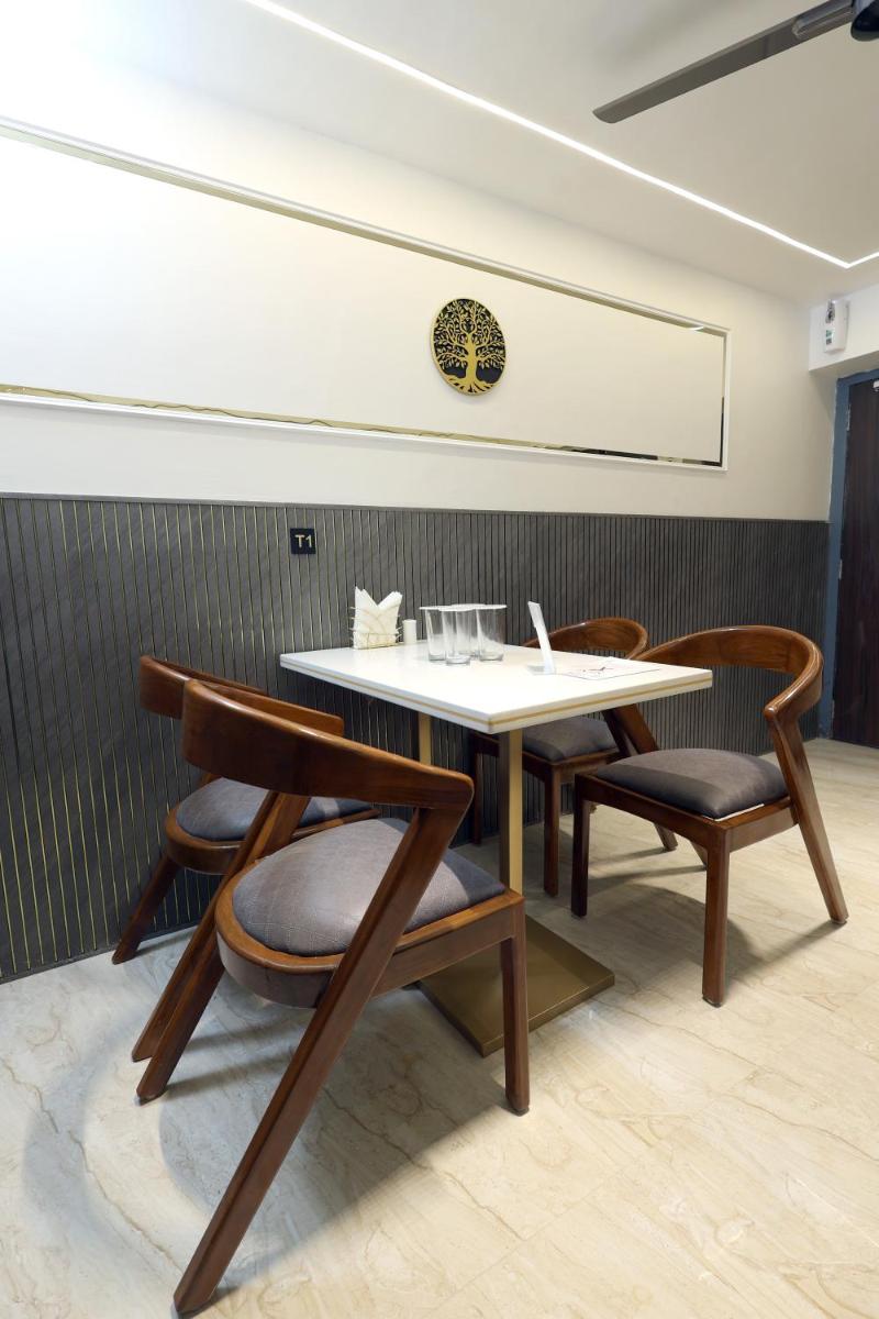 a table and chairs in a room at MyOtel - Santacruz in Mumbai