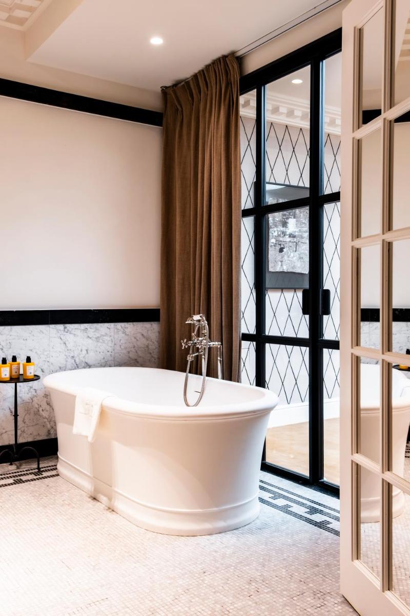 une baignoire dans une salle de bain avec une fenêtre dans l'établissement Hôtel de Berri Champs-Élysées, a Luxury Collection Hotel, à Paris 37 autres photos