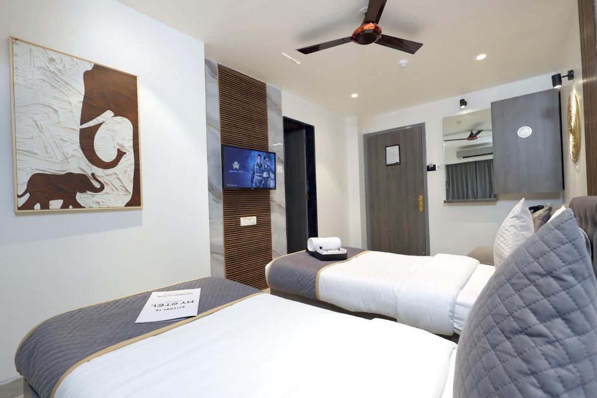 a hotel room with two beds and a flat screen tv at MyOtel - Santacruz in Mumbai