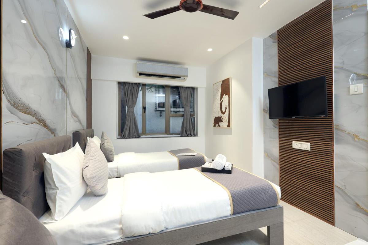 a bedroom with a bed and a flat screen tv at MyOtel - Santacruz in Mumbai