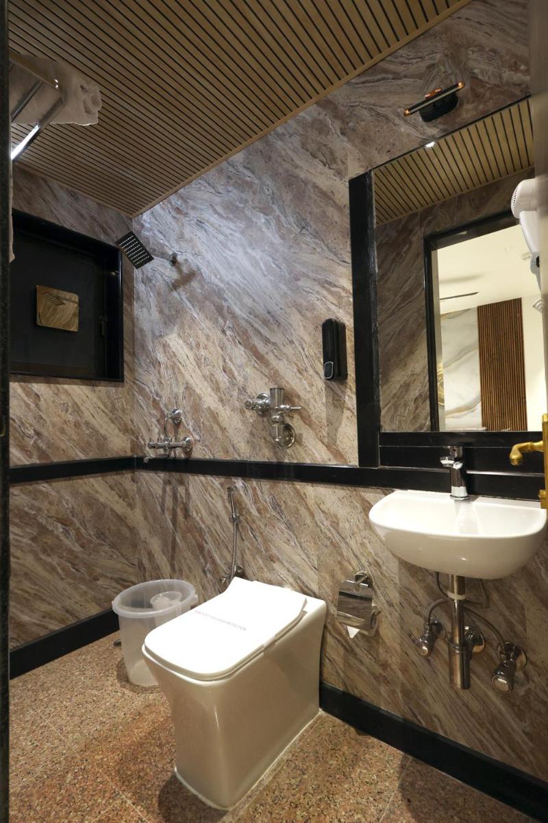 a bathroom with a sink and a toilet and a mirror at MyOtel - Santacruz in Mumbai