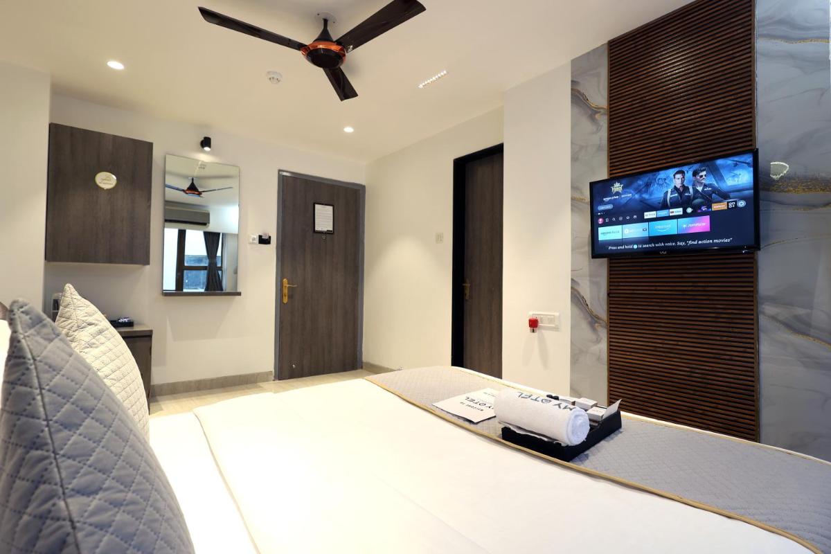 a bedroom with a bed and a flat screen tv at MyOtel - Santacruz in Mumbai