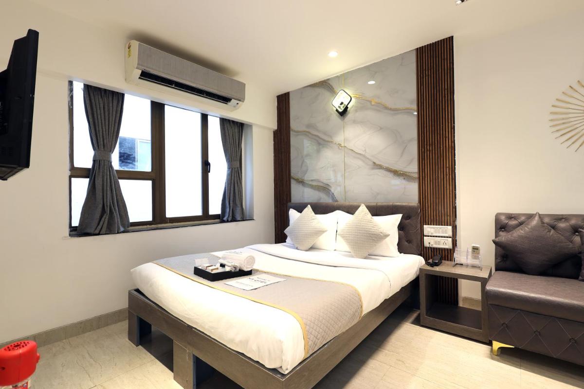 a hotel room with a bed and a chair at MyOtel - Santacruz in Mumbai