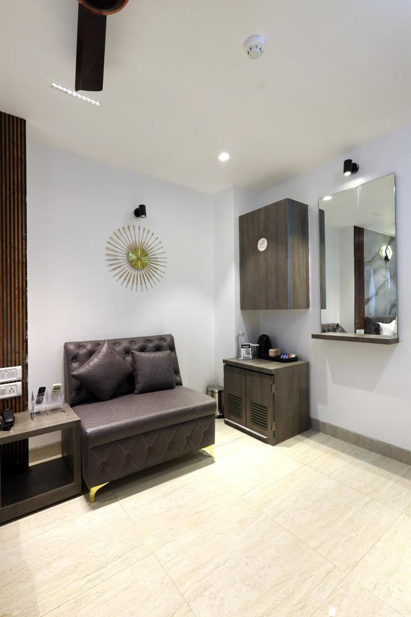 a living room with a couch and a mirror at MyOtel - Santacruz in Mumbai
