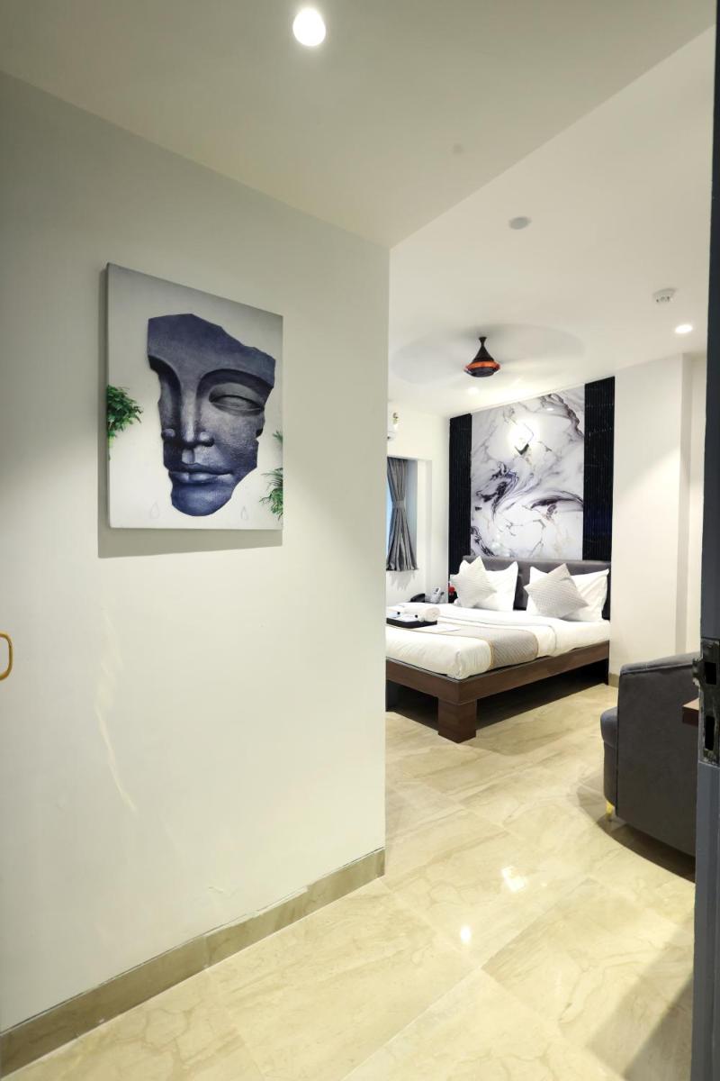 a living room with a bed and a wall with paintings at MyOtel - Santacruz in Mumbai
