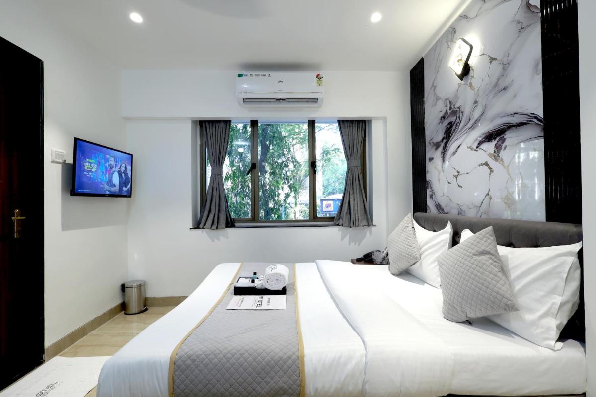 a bedroom with a large bed and a window at MyOtel - Santacruz in Mumbai