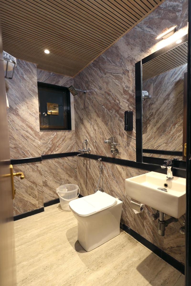 a bathroom with a sink and a toilet and a mirror at MyOtel - Santacruz in Mumbai a bathroom with a sink and a toilet and a mirror at MyOtel - Santacruz in Mumbai