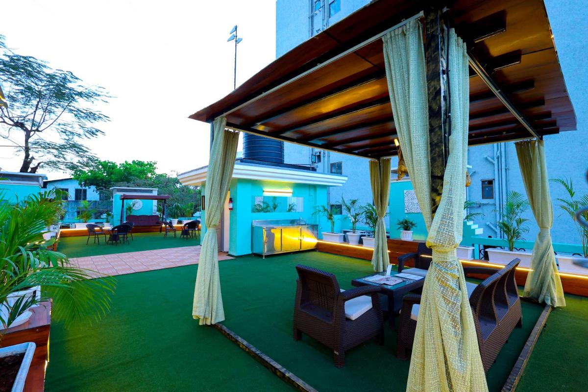 a patio with a table and chairs and a building at MyOtel - Santacruz in Mumbai