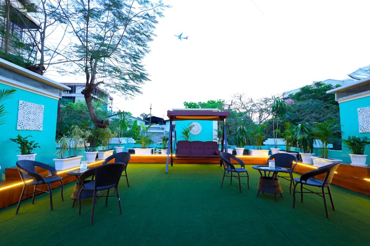 a room with chairs and a stage with a screen at MyOtel - Santacruz in Mumbai