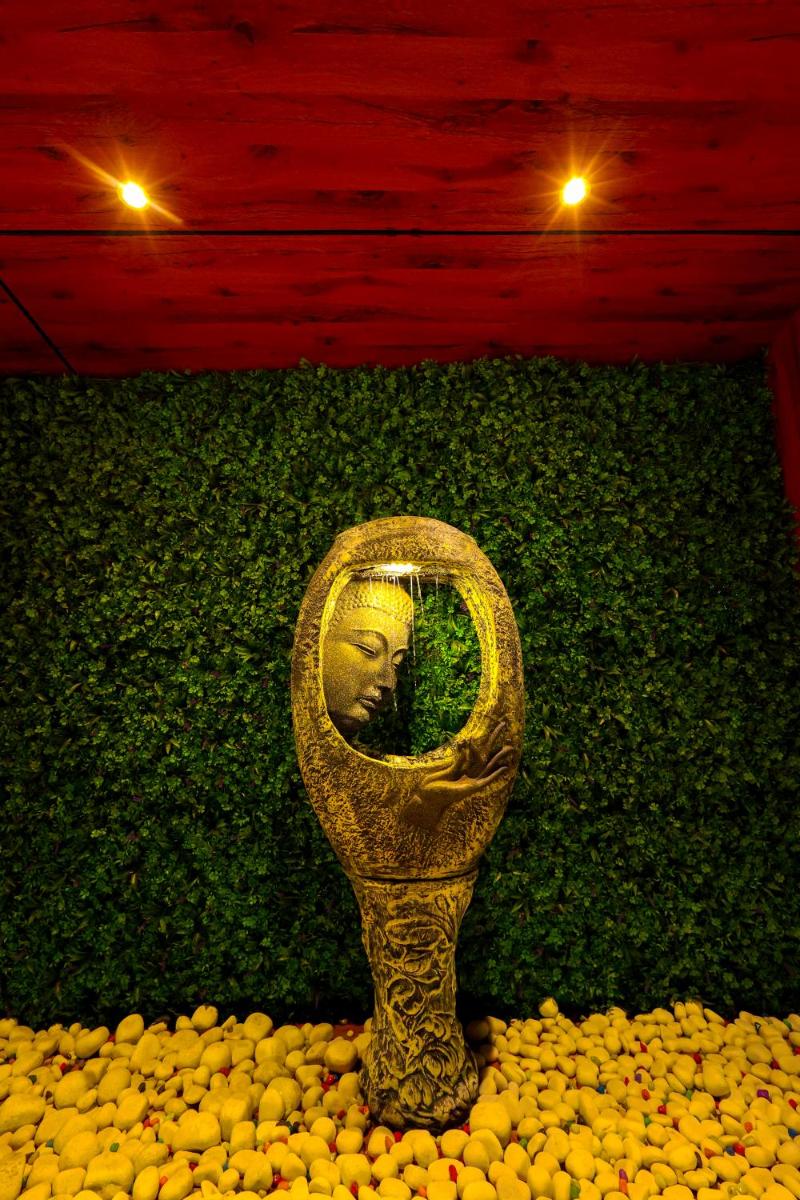 a mirror with a face in it in a field of flowers at MyOtel - Santacruz in Mumbai