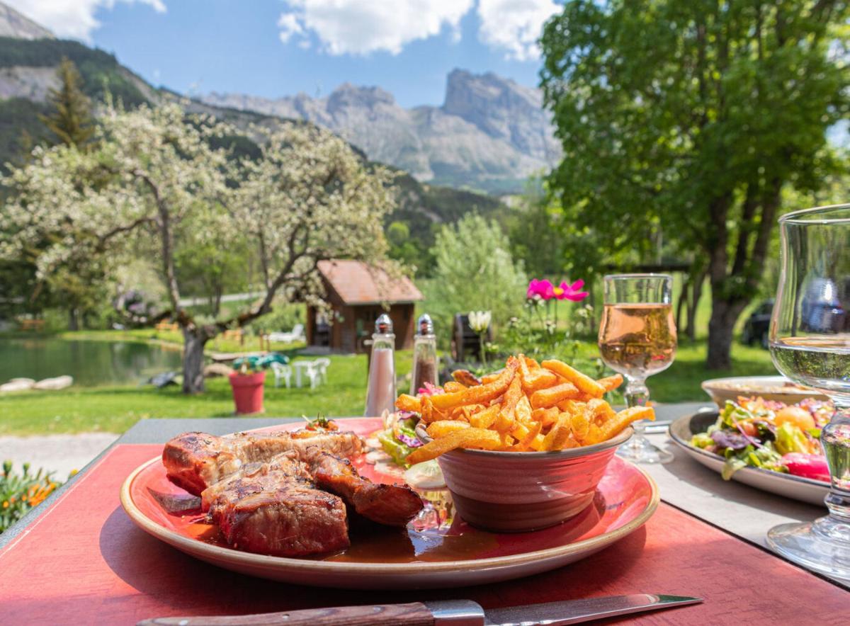 une assiette de nourriture avec de la viande et des frites sur une table dans l'établissement La Neyrette, à Saint-Disdier