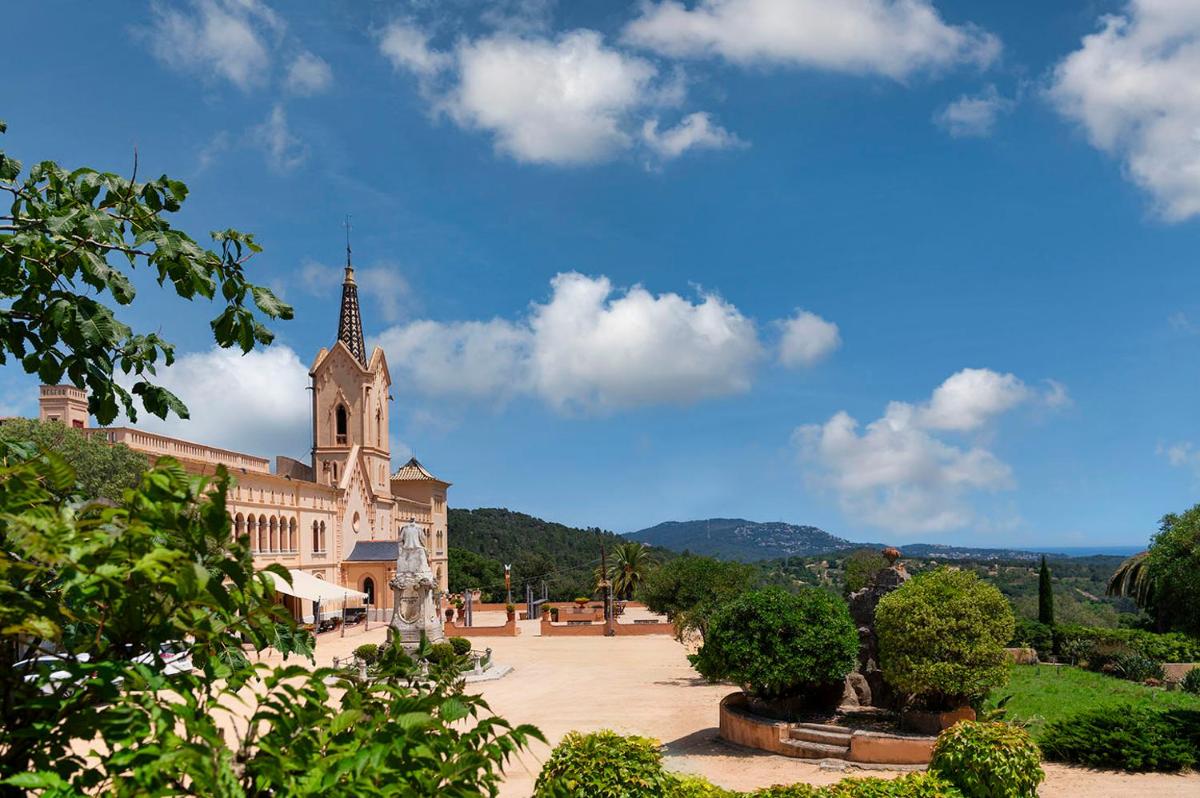 un gran edificio con una torre y una iglesia en Sant Pere del Bosc Hotel & Spa - Adults Recommended, en Lloret de Mar