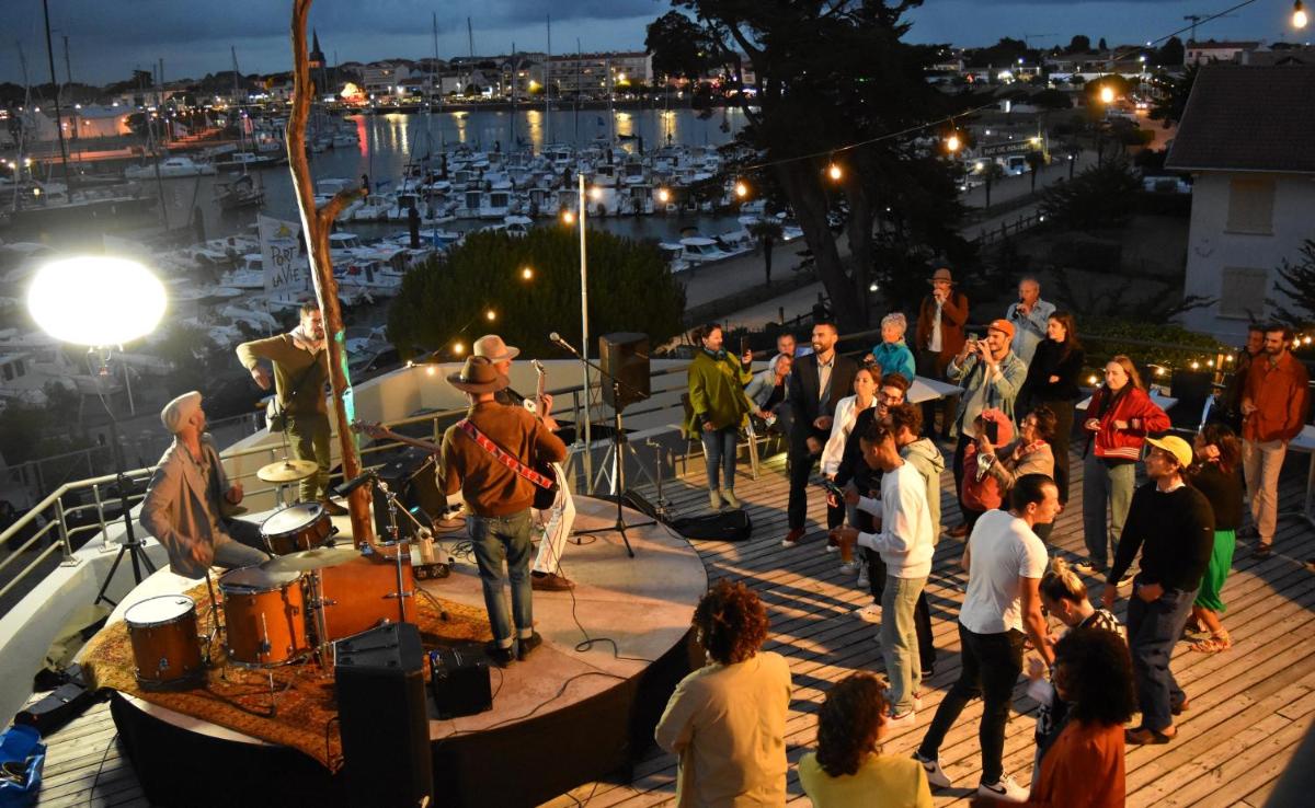 un groupe de personnes debout sur un pont la nuit dans l'établissement TERNELIA Le Vent Du Large, à Saint-Gilles-Croix-de-Vie