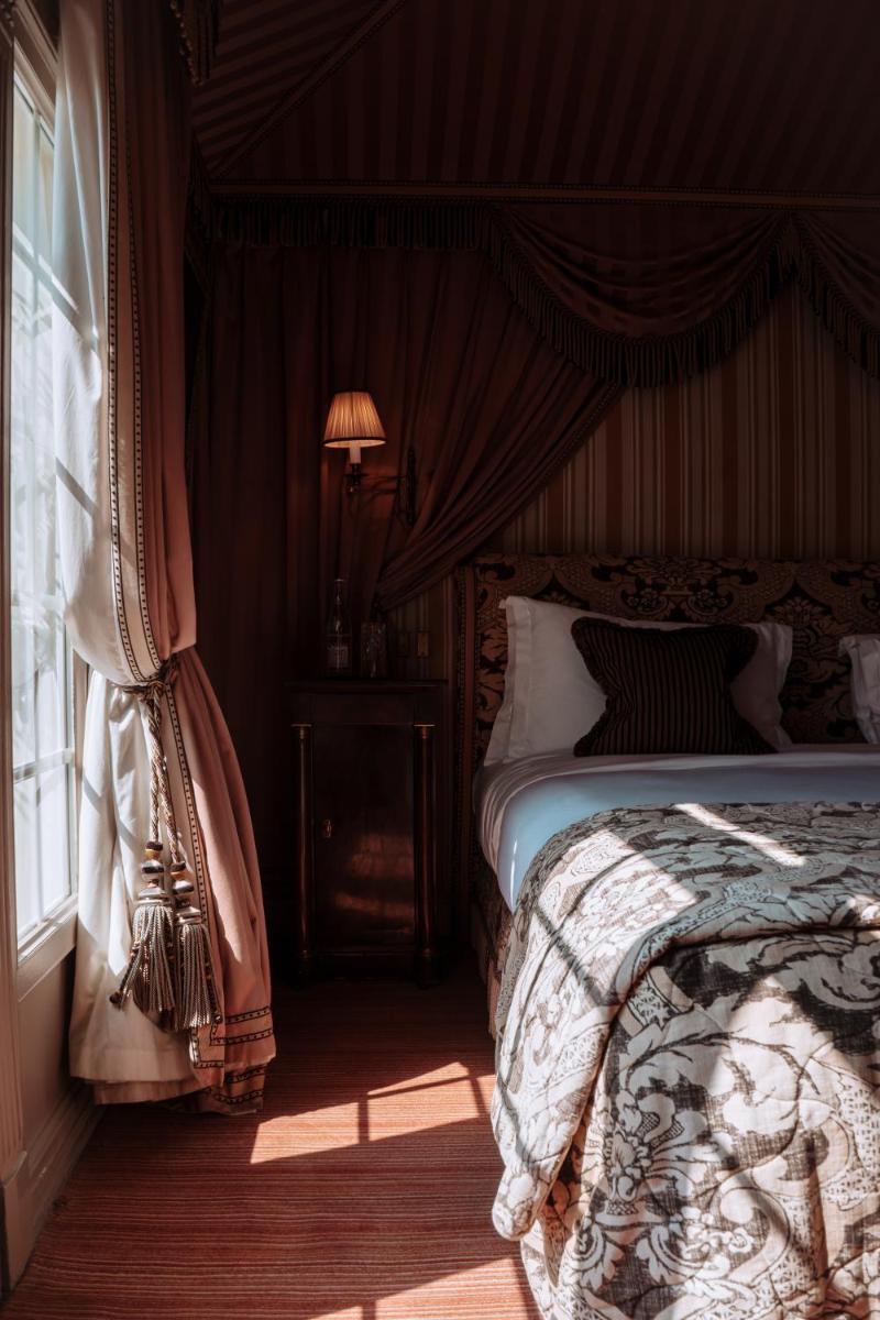 une chambre avec un lit et une fenêtre dans l'établissement L'Hôtel, à Paris