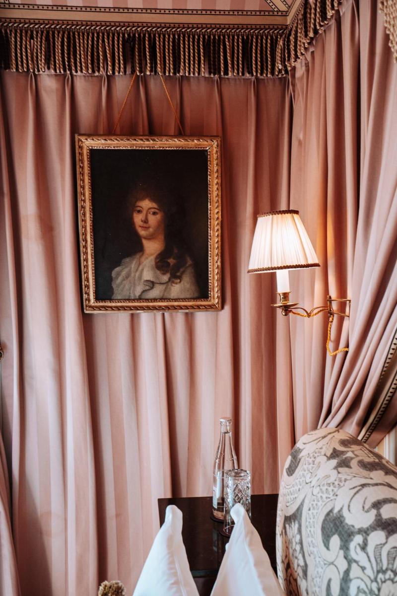 une peinture d'une femme est suspendue sur un mur dans l'établissement L'Hôtel, à Paris