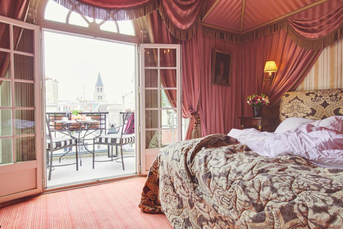 une chambre avec un lit et un balcon avec une table dans l'établissement L'Hôtel, à Paris 37 autres photos