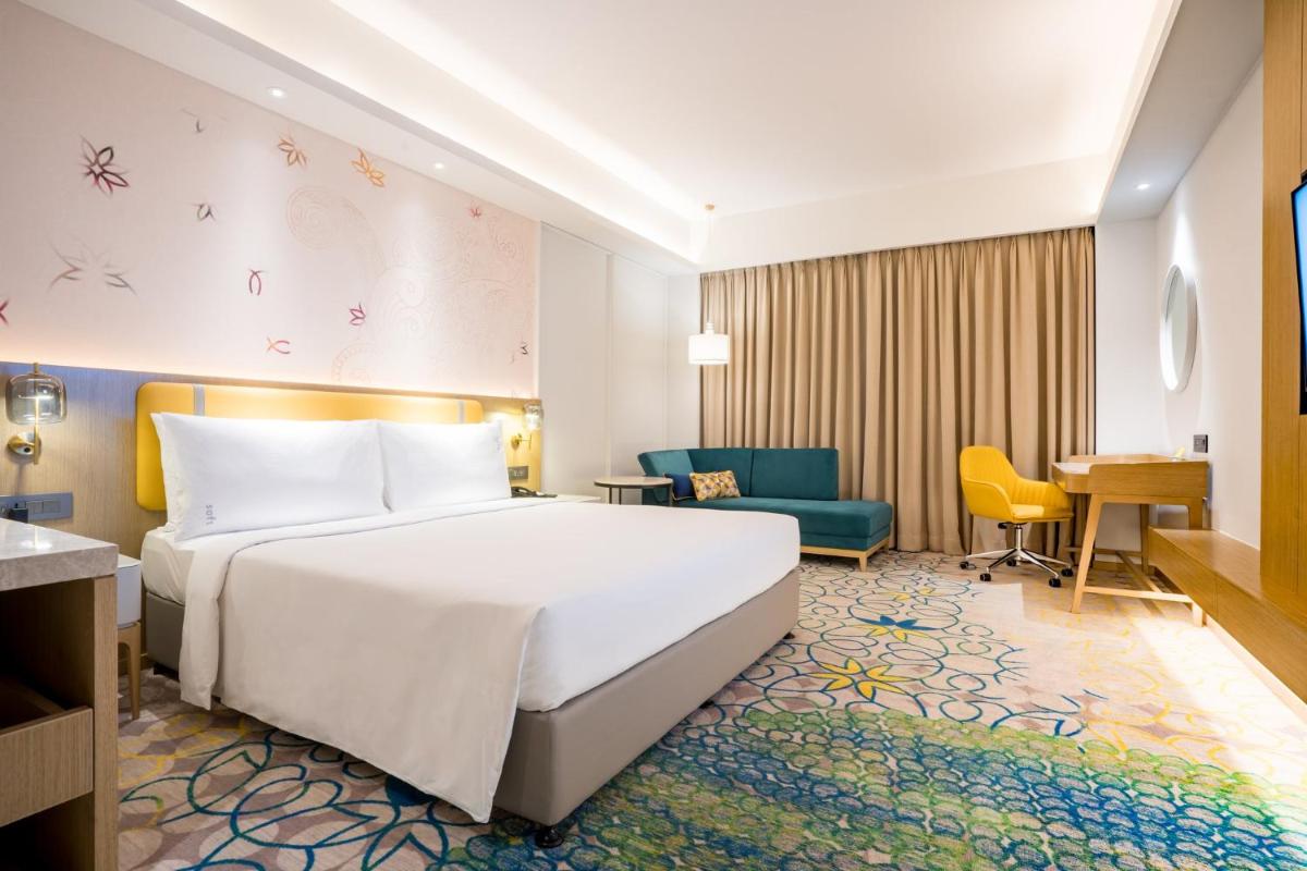 a hotel room with a bed and a desk at Holiday Inn Lucknow Airport by IHG in Lucknow