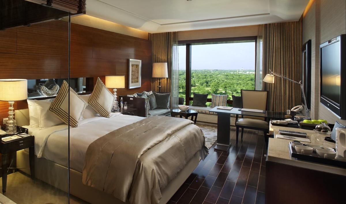 a hotel room with a bed and a desk and a television at The Leela Ambience Gurugram Hotel & Residences - The Luxury Urban Sanctuary in Gurgaon