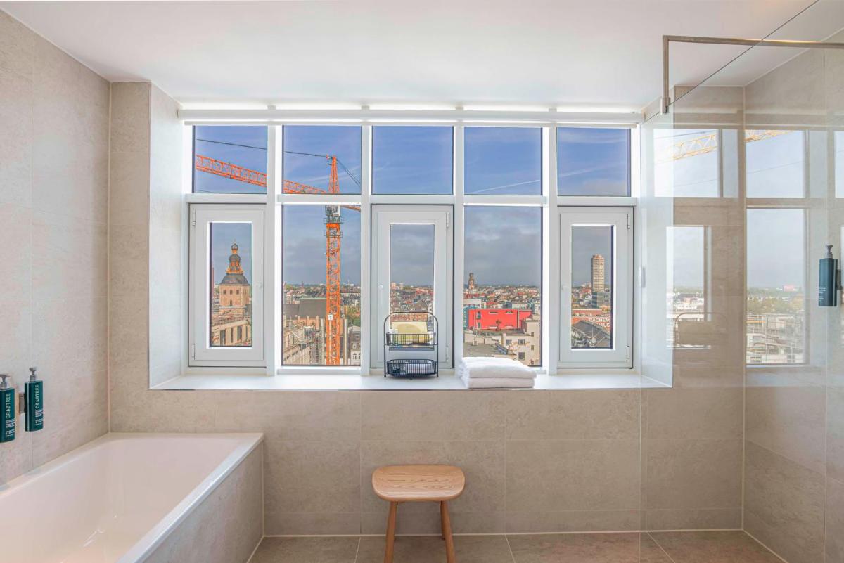 ein Bad mit einer Badewanne und ein Fenster mit Aussicht in der Unterkunft Hilton Cologne in Köln ein Bad mit einer Badewanne und ein Fenster mit Aussicht in der Unterkunft Hilton Cologne in Köln