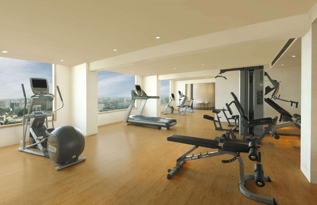 a gym with several exercise equipment in a building at DoubleTree by Hilton-Pune Chinchwad in Pune
