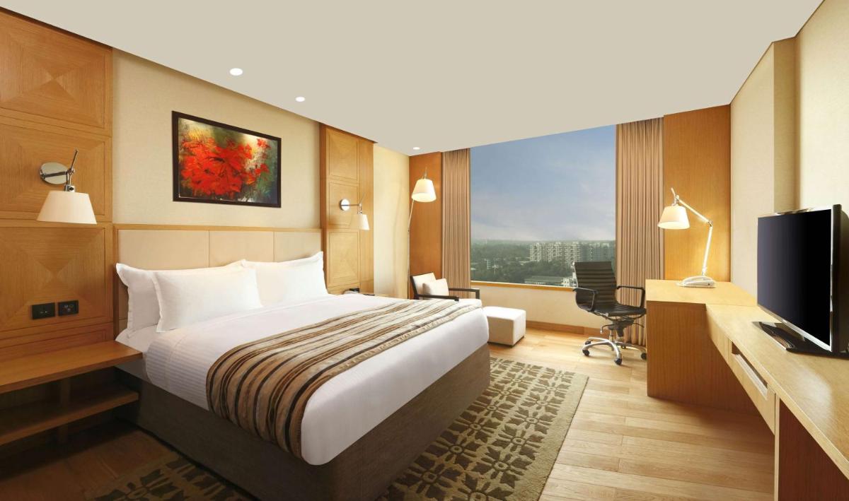a hotel room with a bed and a television at DoubleTree by Hilton-Pune Chinchwad in Pune