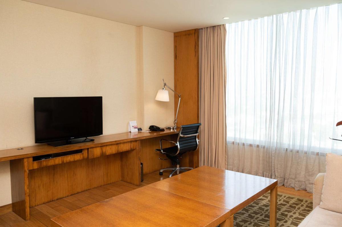 a hotel room with a desk with a flat screen tv at DoubleTree by Hilton-Pune Chinchwad in Pune