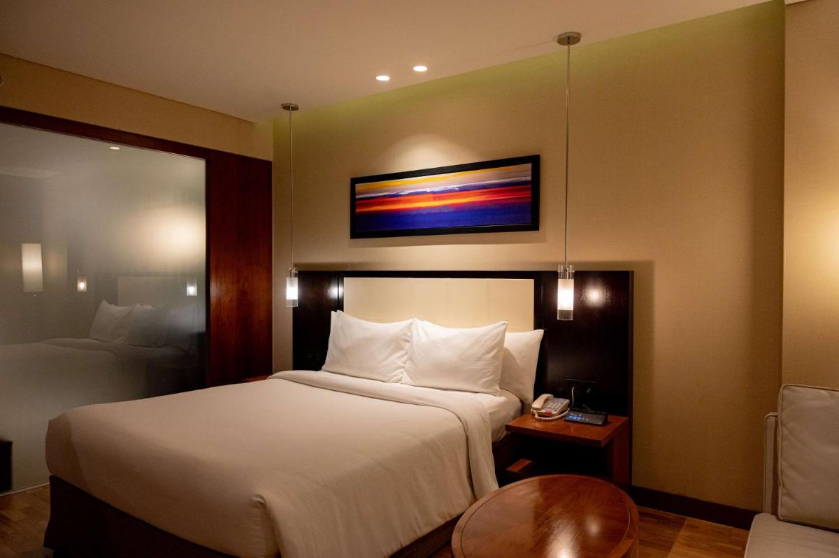 a hotel room with a bed and a tv on the wall at DoubleTree by Hilton-Pune Chinchwad in Pune