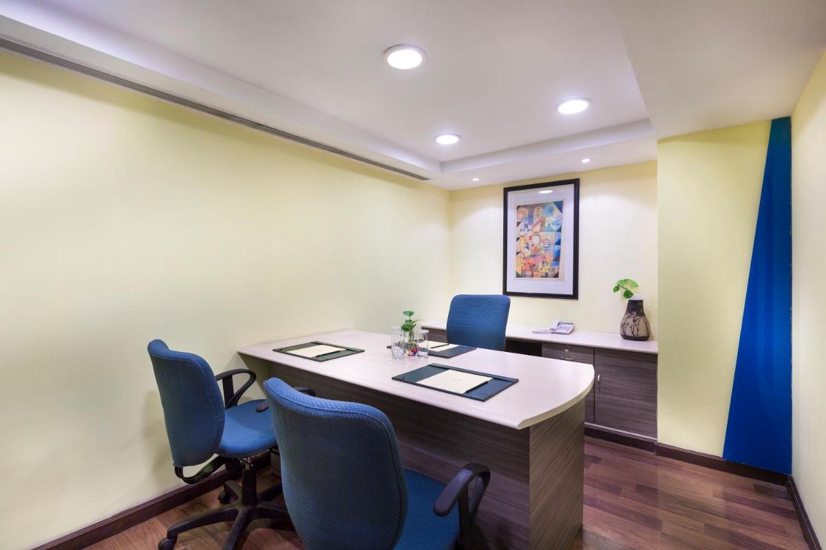an office with a table and blue chairs at Grand Chennai by GRT Hotels in Chennai