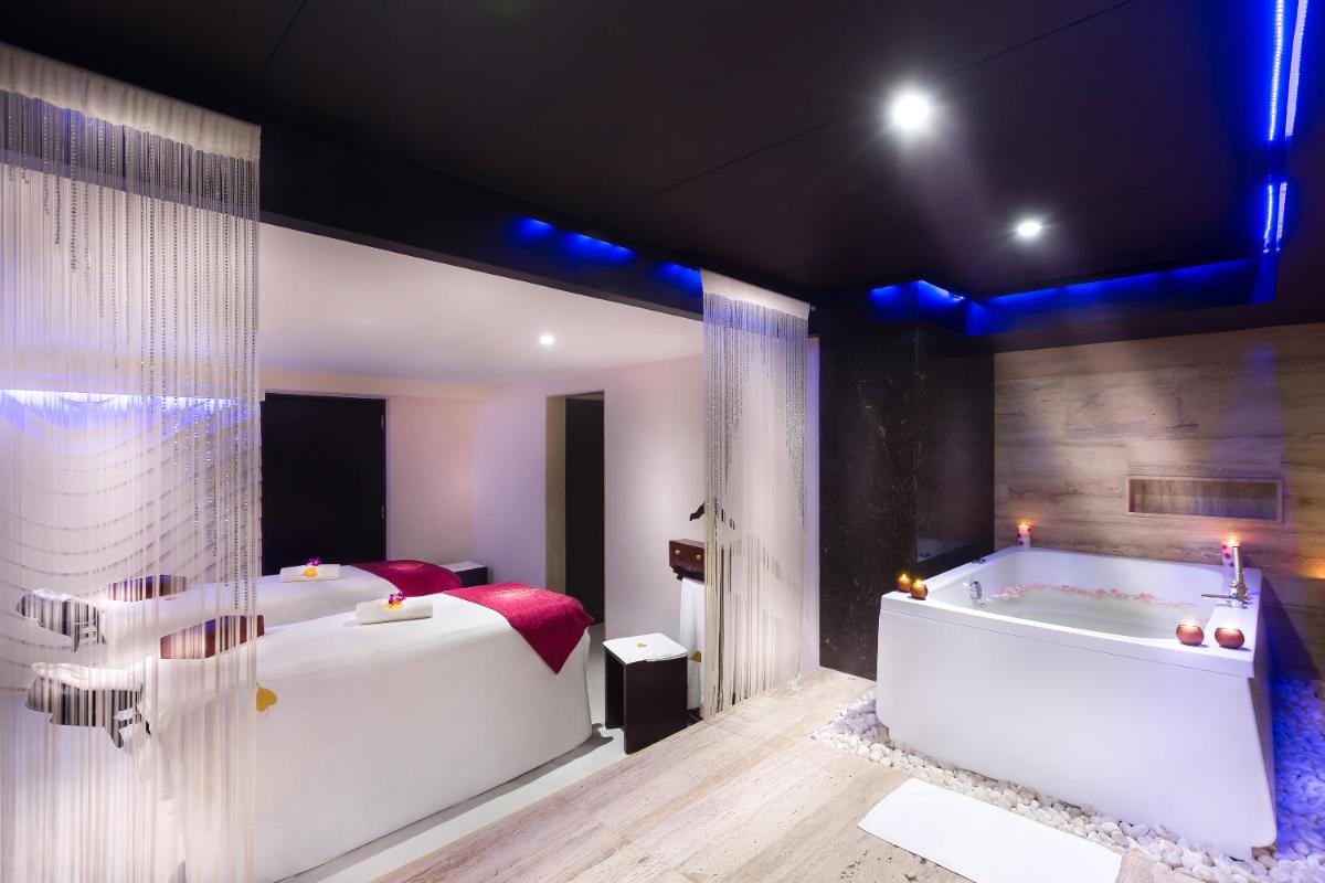 a bedroom with a large bed and a bath tub at Grand Chennai by GRT Hotels in Chennai