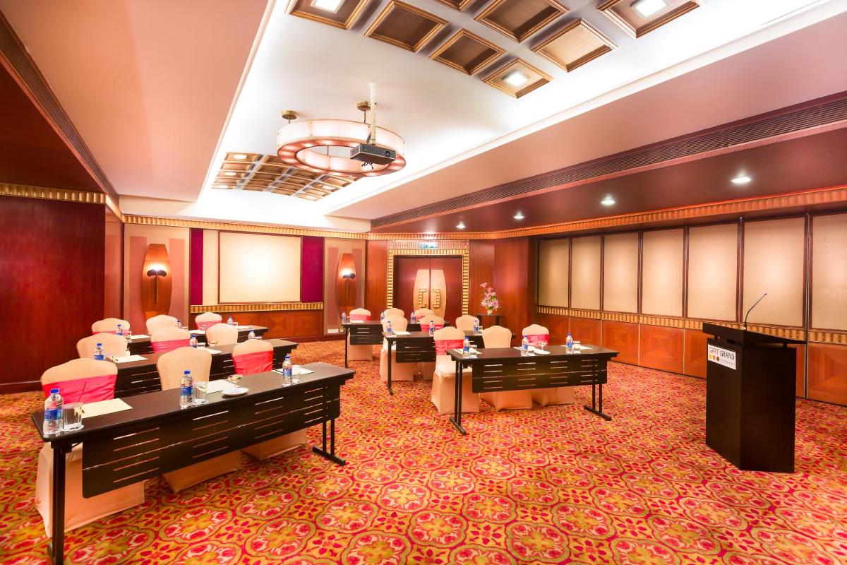 a conference room with chairs and a podium at Grand Chennai by GRT Hotels in Chennai