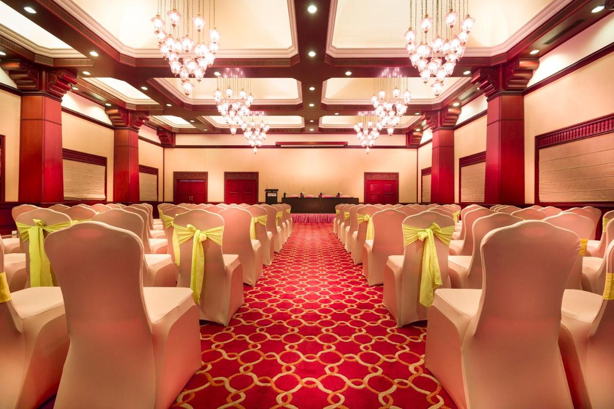 a banquet hall with white chairs and a stage at Grand Chennai by GRT Hotels in Chennai