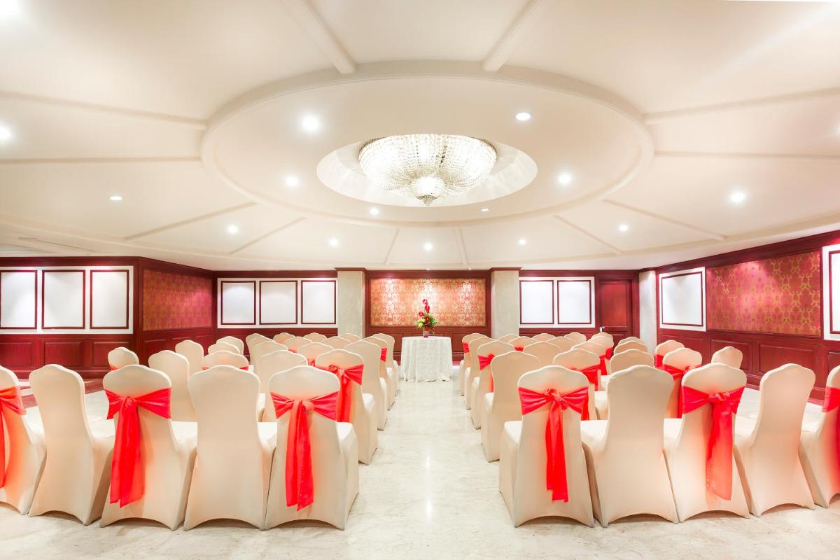a banquet hall with rows of chairs with red bows at Grand Chennai by GRT Hotels in Chennai