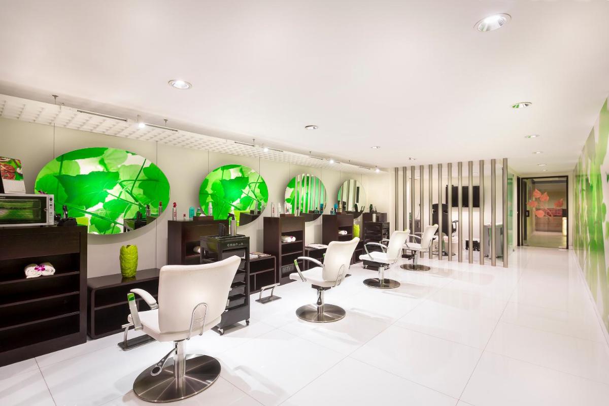 a hair salon with white chairs and green mirrors at Grand Chennai by GRT Hotels in Chennai