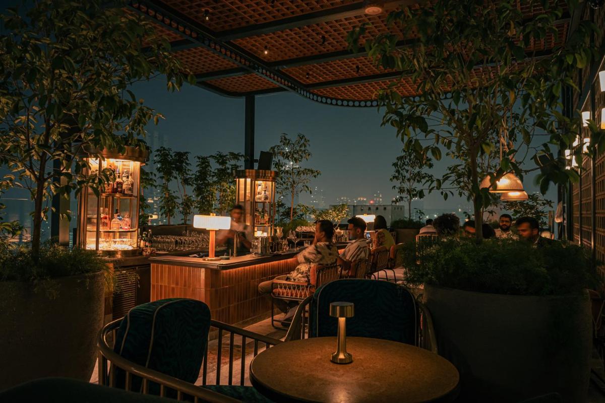 a restaurant with a table and people sitting on the patio at Four Seasons Hotel Mumbai in Mumbai