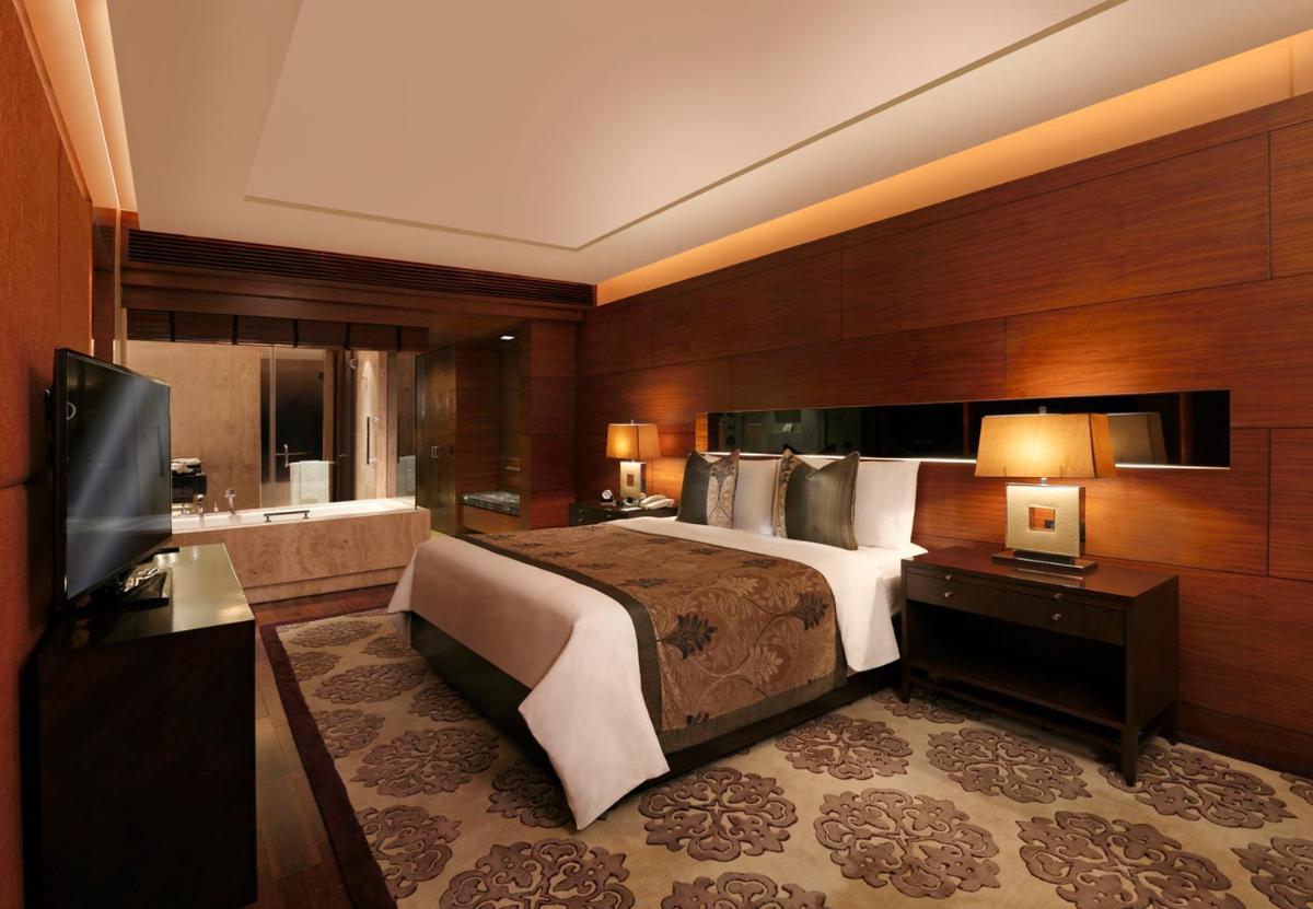 a bedroom with a large bed and a bathroom at The Leela Ambience Gurugram Hotel & Residences - The Luxury Urban Sanctuary in Gurgaon